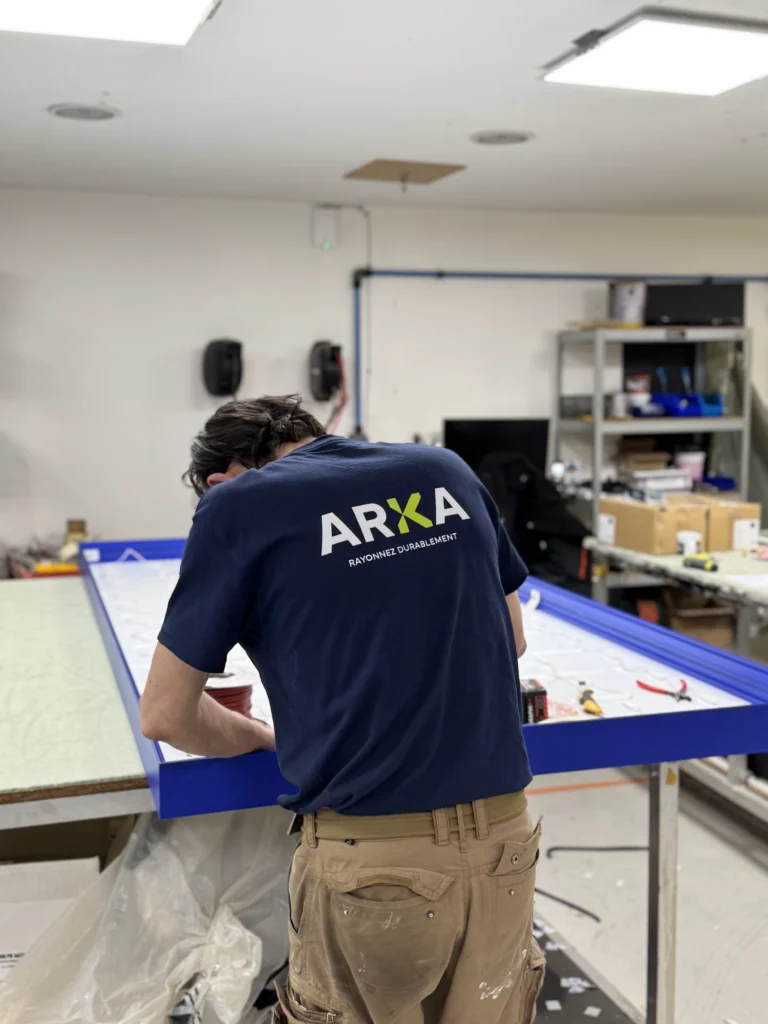 Technicien ARKA assemblant un caisson lumineux dans l’atelier de production